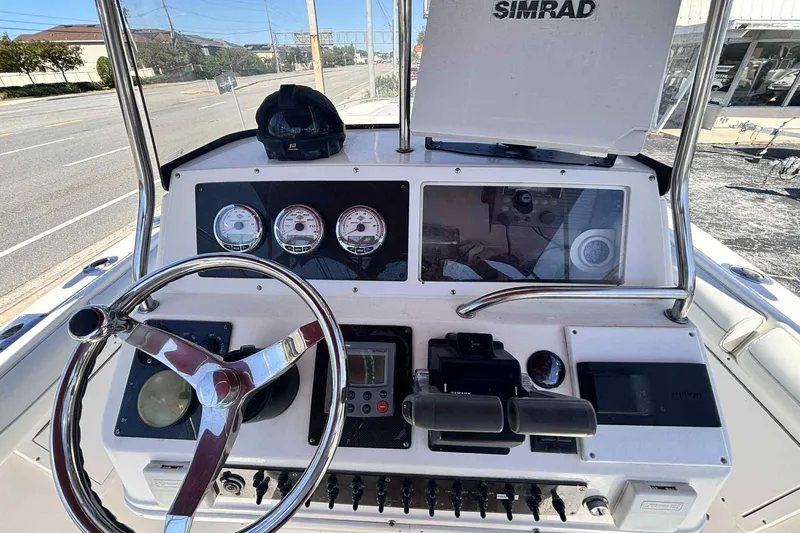Slide: The Image of 1997 Wellcraft 302 Scarab boat dashboard with steering wheel and navigation instruments. - 33