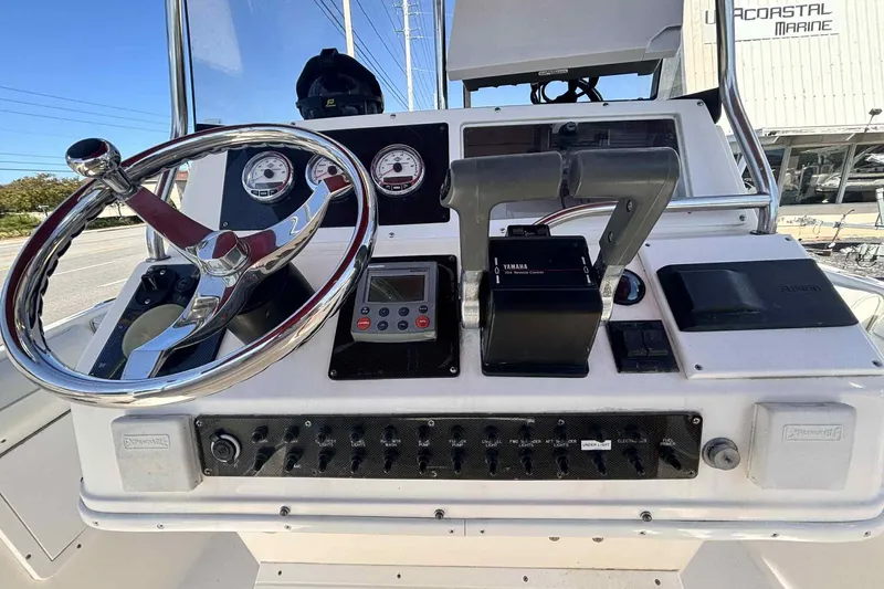 Slide: The Image of 1997 Wellcraft 302 Scarab boat interior with maroon canopy, steering console, and water view. - 5