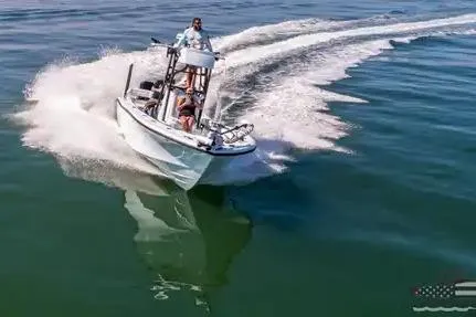Slide: The Image of 2021 Yellowfin 26 Hybrid boat cruising on open water, creating a dynamic wake. - 14