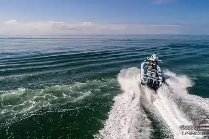 Slide: The Image of 2021 Yellowfin 26 Hybrid boat cruising on open water, leaving a wake behind. - 17