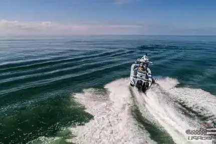 Slide: The Image of 2021 Yellowfin 26 Hybrid boat cruising on open water, leaving a wake behind. - 18