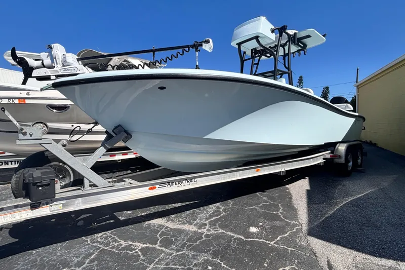 Slide: The Image of 2021 Yellowfin 26 Hybrid boat on trailer under clear blue sky. - 25