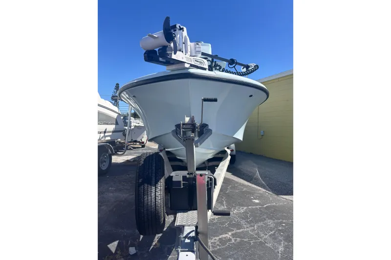 Slide: The Image of 2021 Yellowfin 26 Hybrid boat on trailer, parked outdoors under clear blue sky. - 27