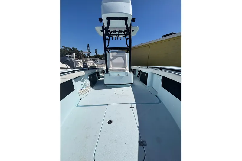 Slide: The Image of 2021 Yellowfin 26 Hybrid boat deck with center console and clear blue sky. - 30