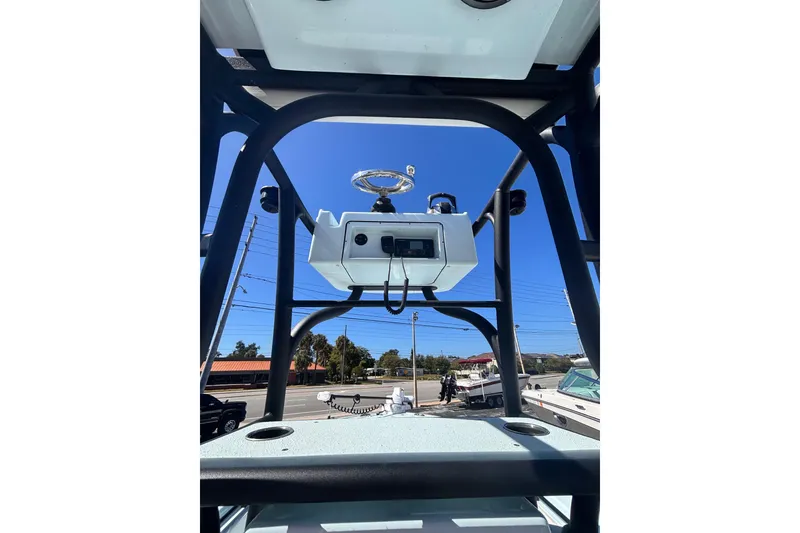 Slide: The Image of 2021 Yellowfin 26 Hybrid boat console with steering wheel, outdoor setting. - 32