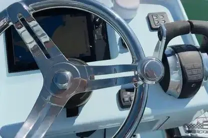Slide: The Image of Steering wheel and controls of a 2021 Yellowfin 26 Hybrid boat. - 38
