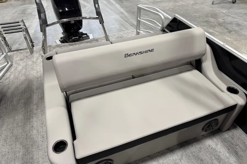 Slide: The Image of 2026 Berkshire 24 UL LE boat interior with beige seating and cup holders. - 11
