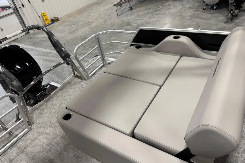 Slide: The Image of 2026 Berkshire 24 UL LE pontoon boat interior with plush seating and motor. - 14