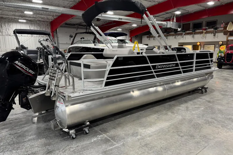 Slide: The Image of 2026 Berkshire 24 UL LE pontoon boat in showroom with Mercury outboard motor. - 4
