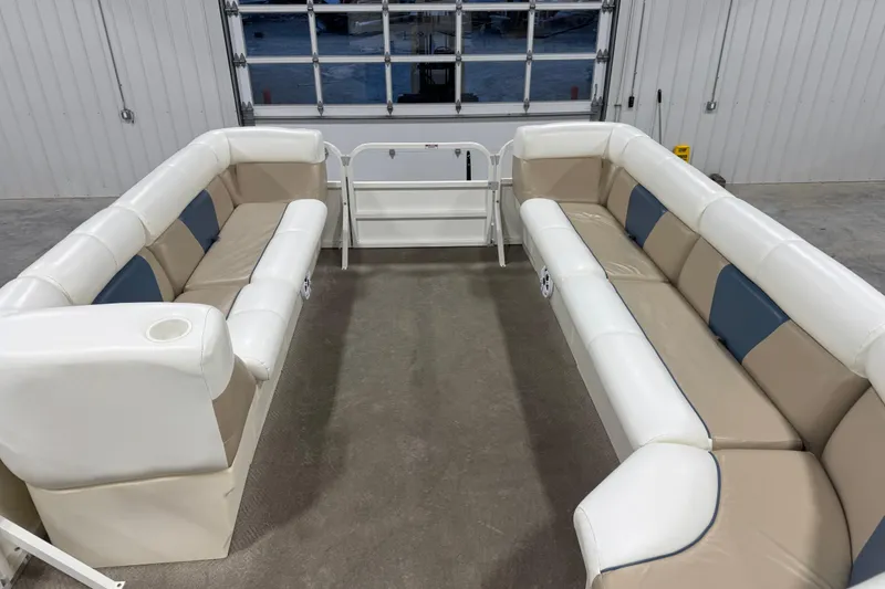 Slide: The Image of 2008 Bentley Pontoons 243 Cruise interior with beige and white seating in a garage setting. - 11