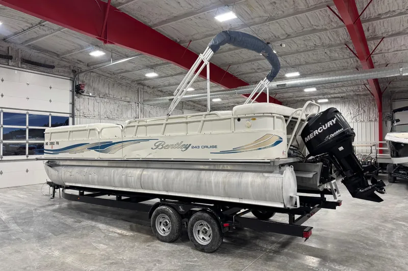 Slide: The Image of 2008 Bentley Pontoons 243 Cruise boat with Mercury engine in a spacious indoor facility. - 3
