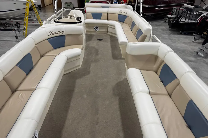 Slide: The Image of 2008 Bentley Pontoons 243 Cruise interior with beige and blue seating in a showroom. - 6