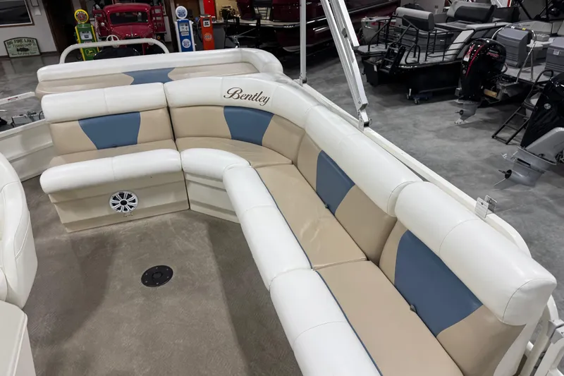 Slide: The Image of 2008 Bentley Pontoons 243 Cruise interior with beige and blue seating in showroom. - 9