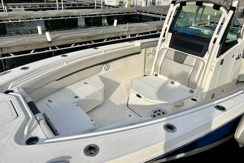 Slide: The Image of 2019 Wellcraft 302 Fisherman boat interior with seating and storage at a marina. - 15