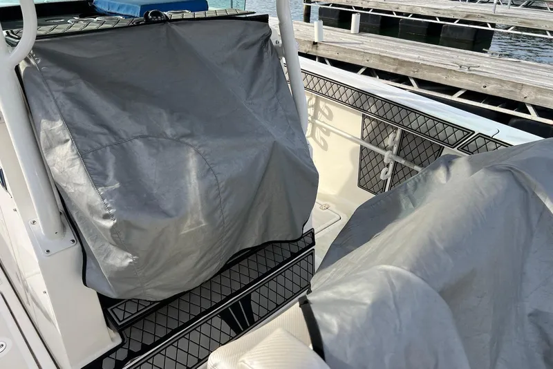 Slide: The Image of 2019 Wellcraft 302 Fisherman boat interior with protective covers at a dock. - 23
