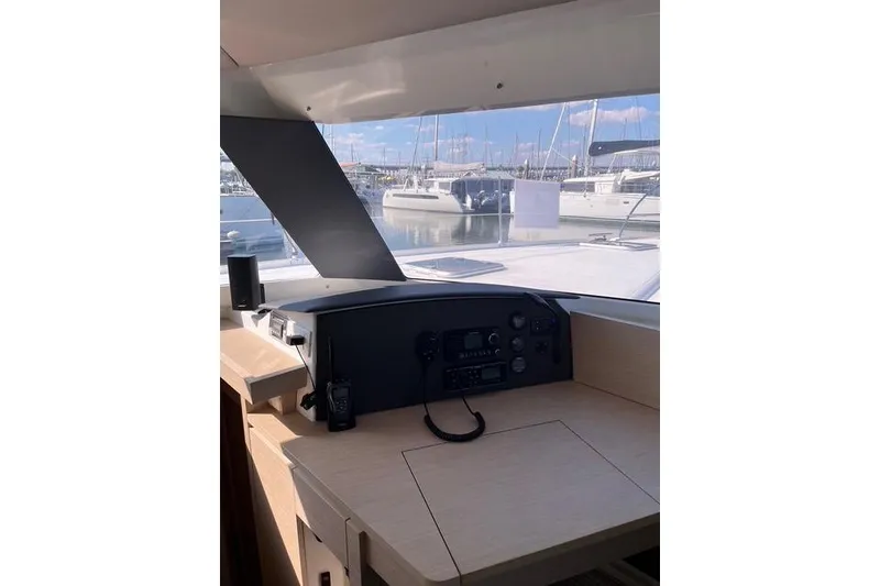 Slide: The Image of Helm of 2018 Fountaine Pajot Helia 44 Evolution catamaran with marina view. - 44