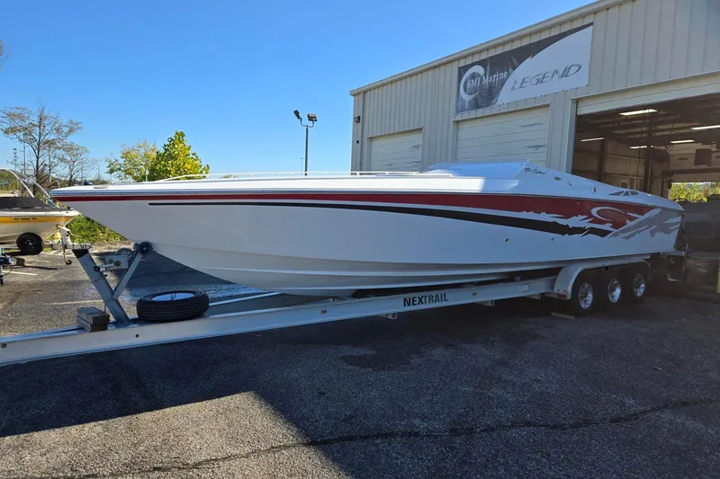 Slide: The Image of 2003 Baja 33 Outlaw speedboat on trailer outside a marine service building. - 1