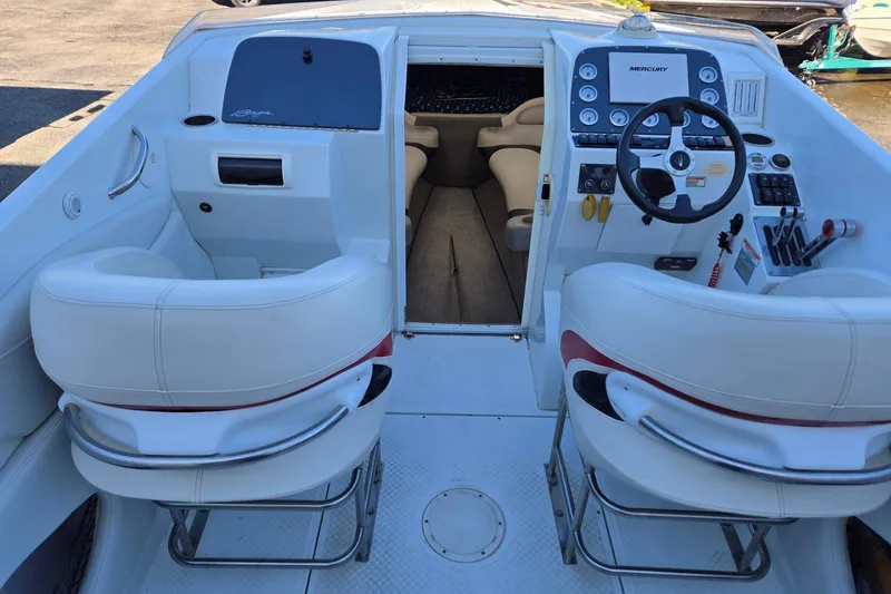 Slide: The Image of 2003 Baja 33 Outlaw boat interior with white seating and control panel. - 12