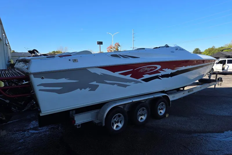 Slide: The Image of 2003 Baja 33 Outlaw speedboat on a trailer, featuring a sleek red and white design. - 2