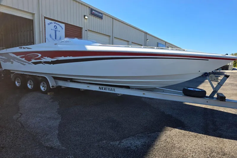 Slide: The Image of 2003 Baja 33 Outlaw speedboat on trailer outside marine service building. - 3