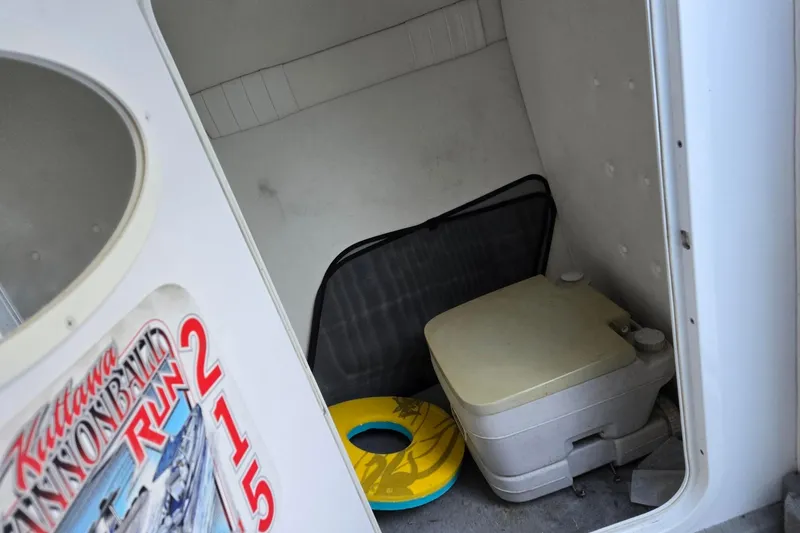 Slide: The Image of Interior of 2003 Baja 33 Outlaw boat with portable toilet and life ring. - 5