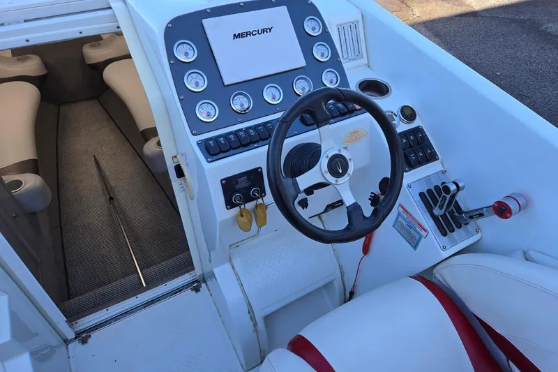 Slide: The Image of 2003 Baja 33 Outlaw boat cockpit with steering wheel and Mercury controls. - 6