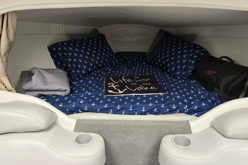 Slide: The Image of Cozy cabin interior of 2003 Baja 33 Outlaw with nautical-themed bedding and decor. - 8