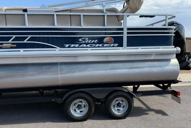 Slide: The Image of 2023 Sun Tracker Fishin' Barge 20 DLX pontoon boat on trailer, side view. - 5