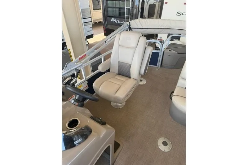 Slide: The Image of 2023 Sun Tracker Fishin' Barge 20 DLX interior with beige captain's chair and helm. - 6
