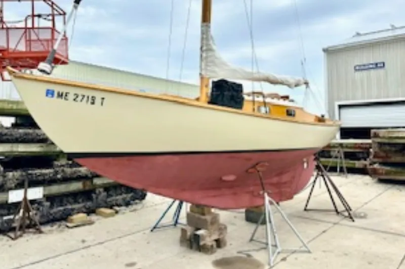 Slide: The Image of 1950 Mason Ostkust Sloop sailboat on stands, displayed outdoors near a building. - 7