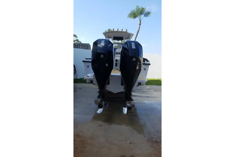 Slide: The Image of 1989 Mako 260 Walk Around boat with dual outboard motors, parked outdoors. - 12