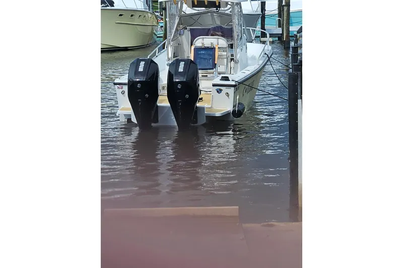 Slide: The Image of 1989 Mako 260 Walk Around boat docked with dual outboard engines. - 13