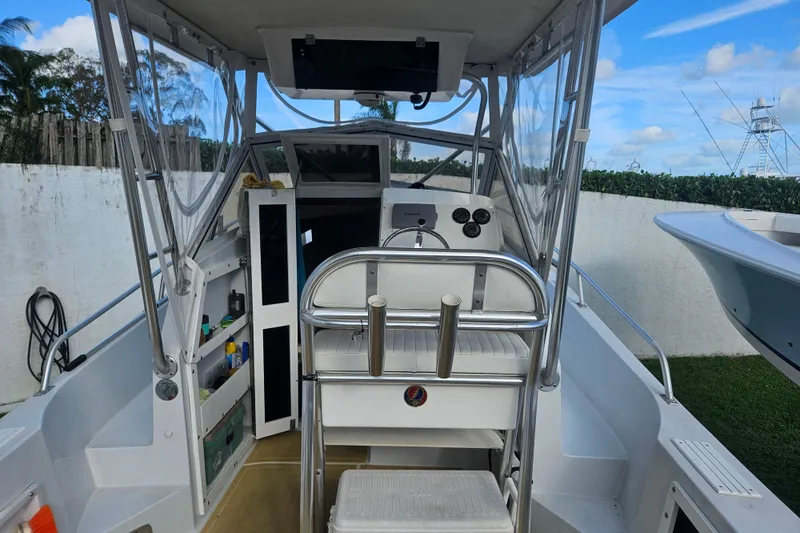 Slide: The Image of 1989 Mako 260 Walk Around boat interior with helm, seating, and storage compartments. - 3