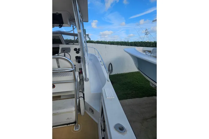 Slide: The Image of 1989 Mako 260 Walk Around boat, side view with clear sky background. - 4