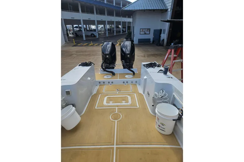 Slide: The Image of 1989 Mako 260 Walk Around boat with dual outboard motors and spacious deck. - 8