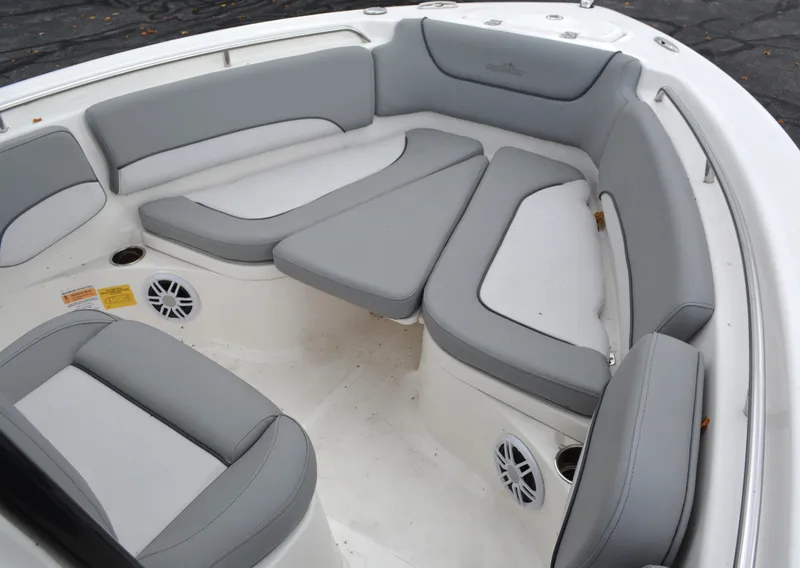 Slide: The Image of 2023 NauticStar 2102 Legacy boat interior with gray cushioned seating and built-in speakers. - 10