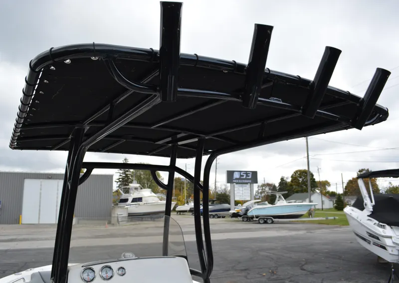 Slide: The Image of 2023 NauticStar 2102 Legacy boat with black T-top and rod holders. - 4