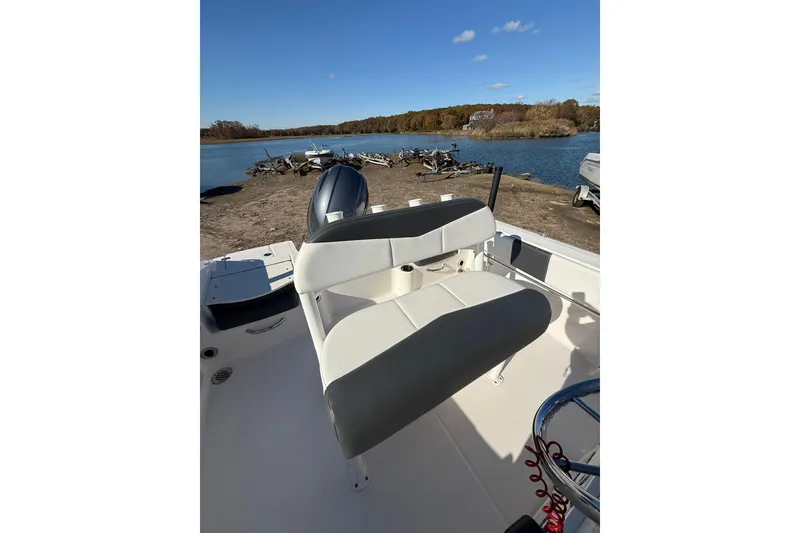 Slide: The Image of 2022 Robalo R180 Center Console boat interior with seating, near a scenic lake. - 12