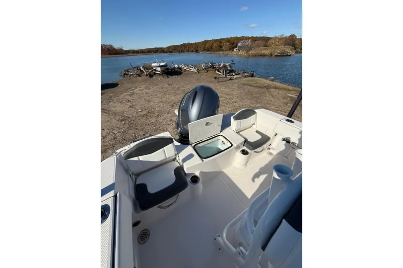 Slide: The Image of 2022 Robalo R180 Center Console boat interior by a scenic lake. - 13