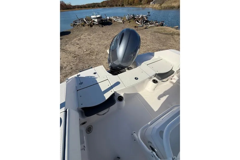 Slide: The Image of 2022 Robalo R180 Center Console boat with outboard motor near a lake. - 14