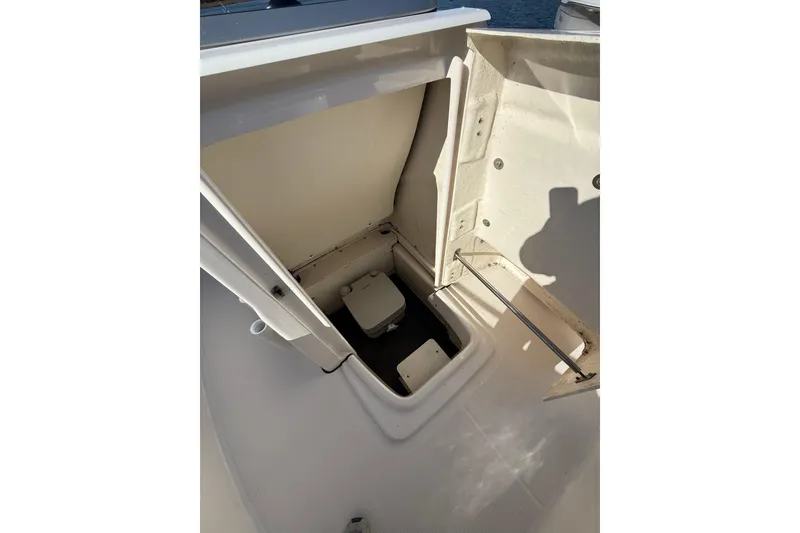 Slide: The Image of 2022 Robalo R180 Center Console storage compartment with open hatch, showcasing interior space. - 17