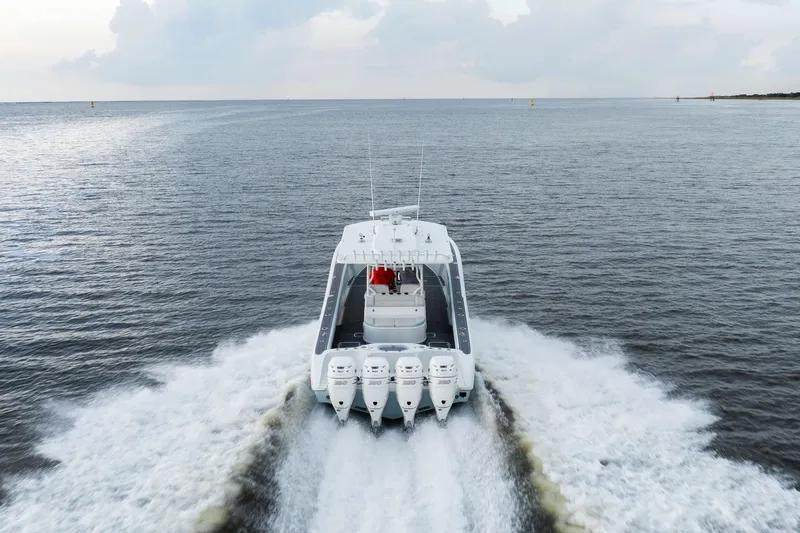 Slide: The Image of 2018 Yellowfin 39 Offshore boat cruising on open water, rear view. - 14