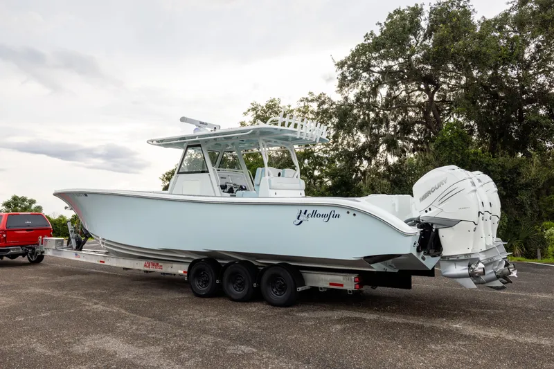 Slide: The Image of 2018 Yellowfin 39 Offshore boat on trailer, parked outdoors with trees in background. - 27