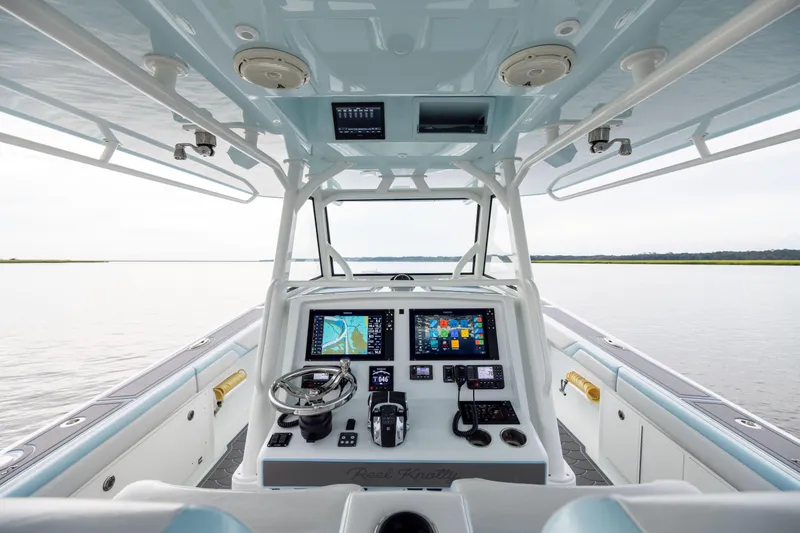 Slide: The Image of 2018 Yellowfin 39 Offshore boat cockpit with advanced navigation system and serene water view. - 52