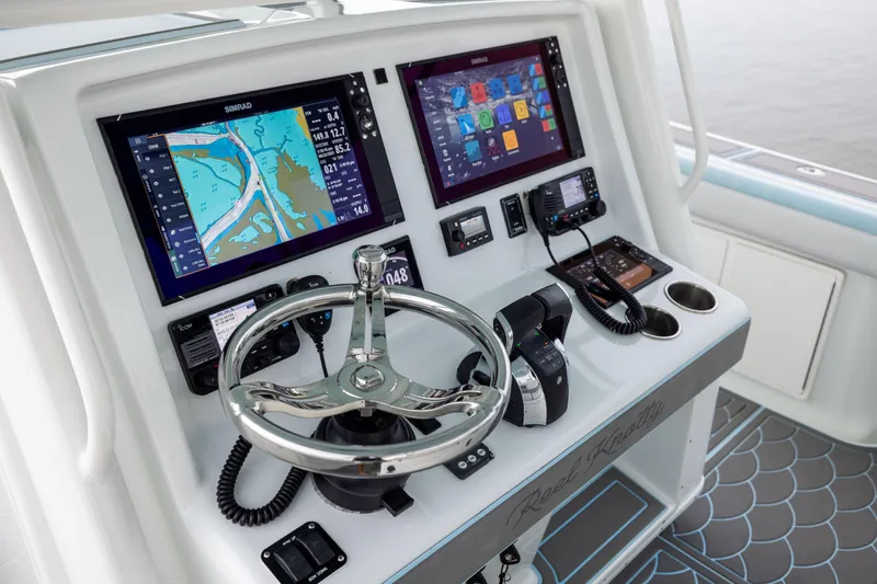 Slide: The Image of 2018 Yellowfin 39 Offshore boat dashboard with navigation screens and steering wheel. - 58