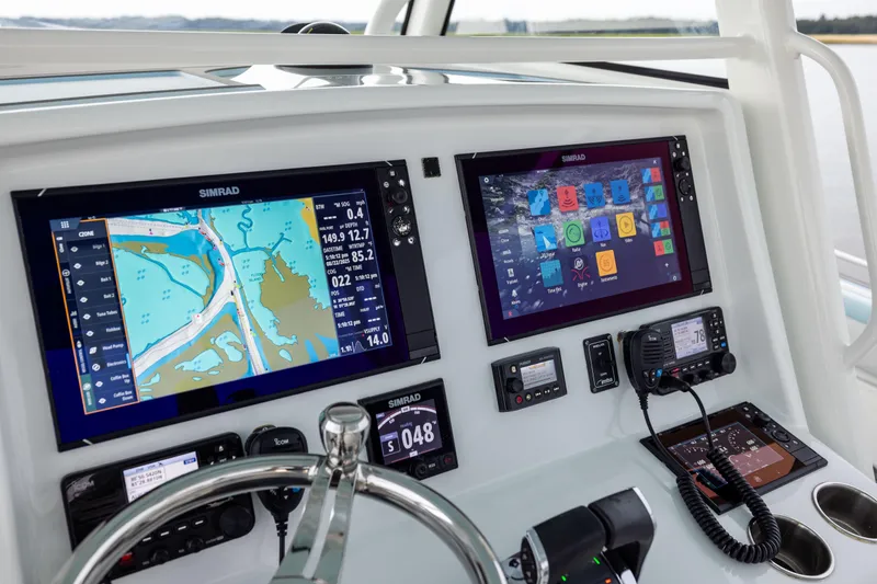 Slide: The Image of 2018 Yellowfin 39 Offshore boat dashboard with Simrad navigation displays and controls. - 59