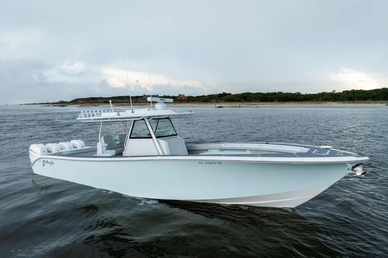 Slide: The Image of 2018 Yellowfin 39 Offshore boat on calm waters near a scenic shoreline. - 6