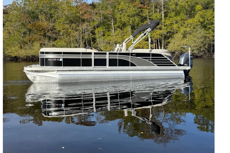 Slide: The Image of 2019 Bennington G 22 GSRFB pontoon boat on calm water with forested background. - 1