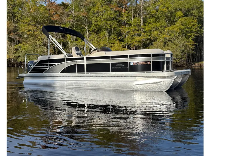 Slide: The Image of 2019 Bennington G 22 GSRFB pontoon boat on a calm lake with forest backdrop. - 4