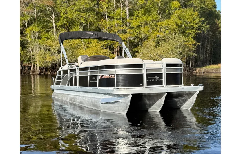 Slide: The Image of 2019 Bennington G 22 GSRFB pontoon boat on a serene lake with lush trees. - 5